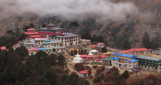 Tengboche, Everest Region, Nepal, Drone shot of the historic Tengboche Monastery complex on a hill surrounded by pine trees and low clouds in the Everest region