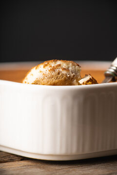 Creamy tiramisu in ceramic bowl being scooped with spoon. Cooking recipes. Selective focus.