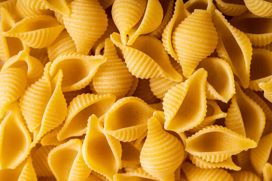 Dry pasta shells as textured background. Shot from above. Background and textures.