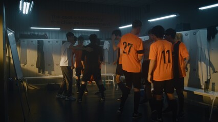 Fototapeta premium Group of Diverse Teenage Boys in Orange Uniforms and Coach Celebrate Win in Locker Room. Male Players Jumping, Shouting, and Hugging. Concept of Pure Euphoria and Emotional Success of Youth Sports.