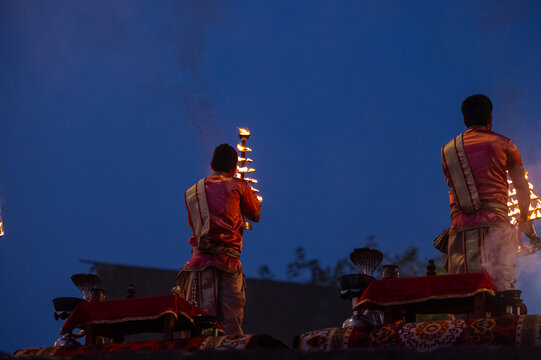 Ganga aarti, Portrait of an young unidentified male priest performing holy river ganga early morning aarti at assi ghat in traditional dress with hindu rituals.