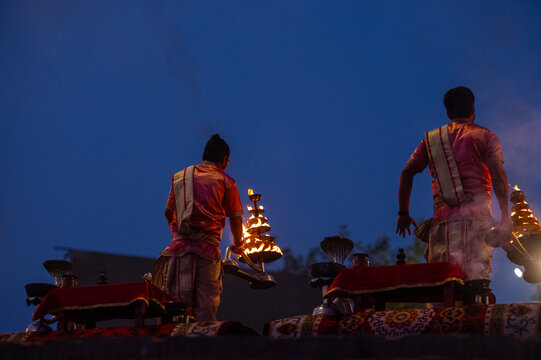 Ganga aarti, Portrait of an young unidentified male priest performing holy river ganga early morning aarti at assi ghat in traditional dress with hindu rituals.