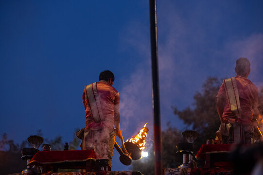 Ganga aarti, Portrait of an young unidentified male priest performing holy river ganga early morning aarti at assi ghat in traditional dress with hindu rituals.