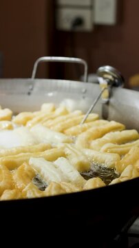 Deep Frying Traditional Chinese Dough Sticks in Large Wok