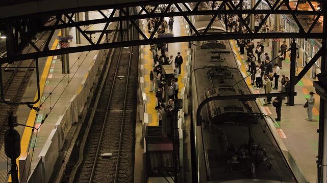Night in Tokyo  :  Commuter Train Arriving at the Platform. Passengers Disembarking and Waiting to Board for the Return Journey  |  Ikebukuro Station, Tokyo, Japan