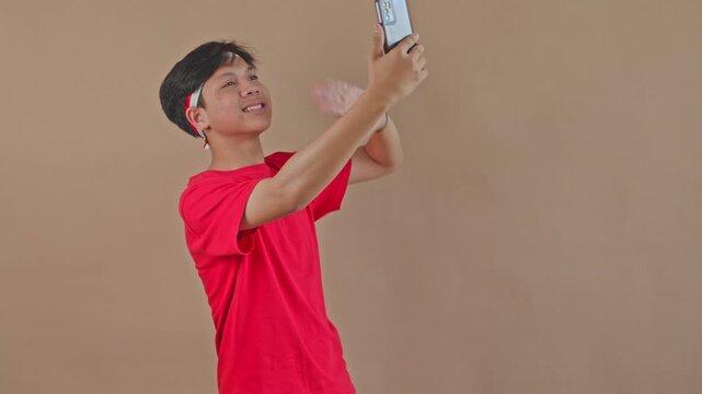Happy male youth greeting followers during Independence Day mobile broadcast