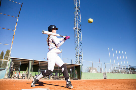 Female batter hitting the ball during a baseball game