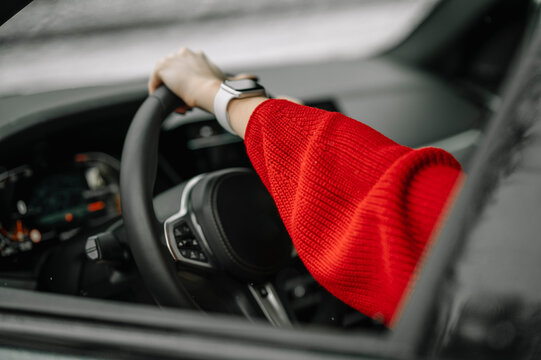 Hand of woman holding steering wheel of car