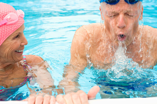 Senior couple swimming and splashing in a thermal pool in Germany