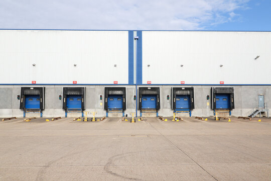 Modern warehouse loading docks with multiple dock doors at distribution center for truck loading, unloading and inbound outbound logistics operations