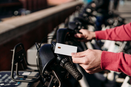Man paying with credit card at electric bicycle sharing system