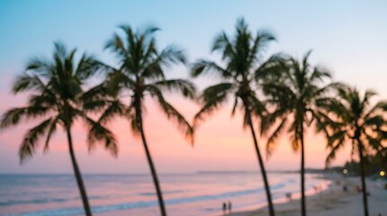 Fototapeta premium Blurred silhouette of palm trees against a soft pastel sunset sky over a tropical beach with ocean waves gently washing onto the sandy shore