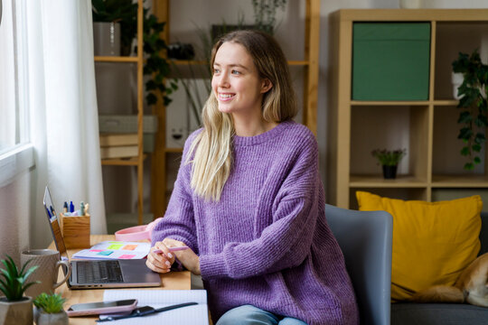 Smiling woman working at home office desk in natural light