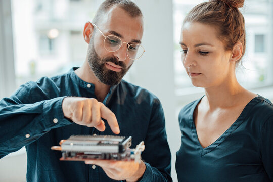 Businessman showing heating module to colleague at home office