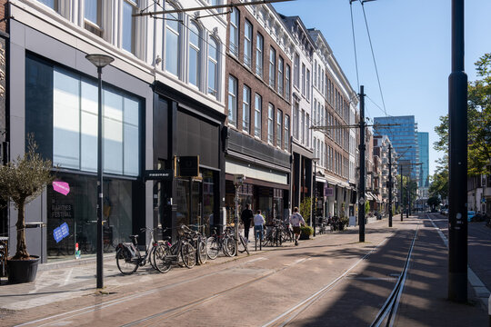 Cyclists and pedestrians near FREITAG Store, tram tracks. Brick facades in Rotterdam, Netherlands