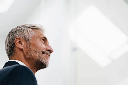 Confident mature businessman looking up