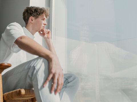 Man looking through window at home