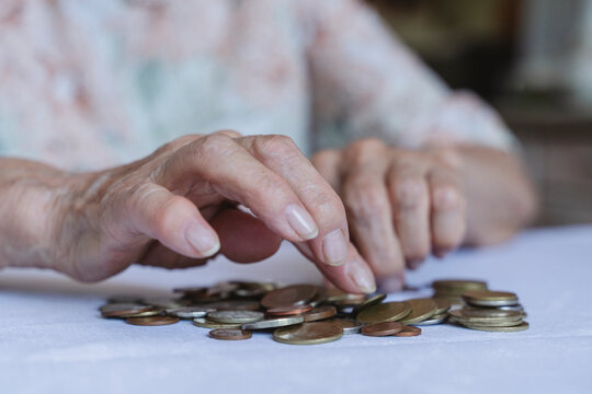 Hands of senior woman counting coins at home