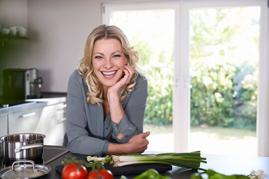 Portrait of happy woman cooking in kitchen