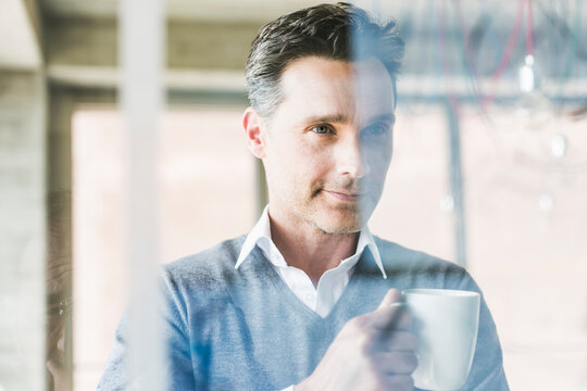 Businessman looking at transparant projection screen in office