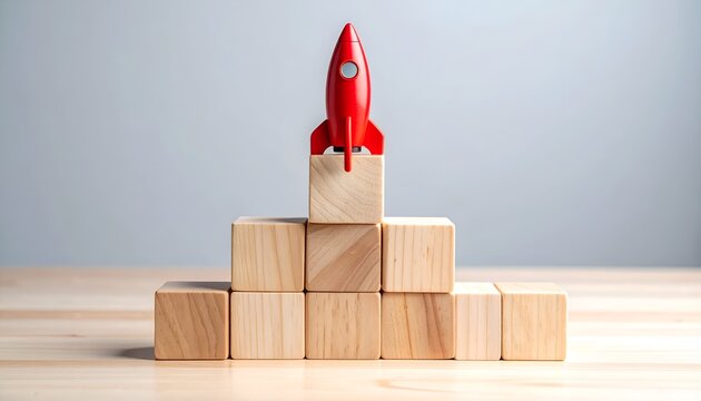 Red rocket on wooden block pyramid, symbolizing business milestones, startup launch, innovation, leadership and long term growth.