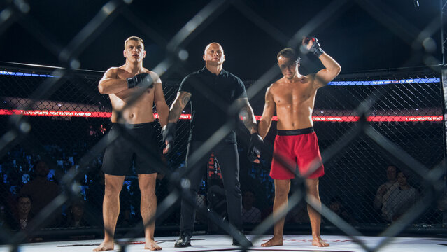 MMA Fighters Fight Await the Fight Result in the Cage as the Referee Lifts One Hand to Declare the Winner. Realistic Documentary Sport Moment With Emotion, Celebration