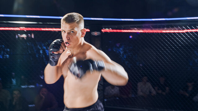 MMA Fighters Fight Battle in a Cage Fight as One Athlete Steps in With Punches and Steady Pressure. the Opponent Keeps Guard and Looks to Counter. 