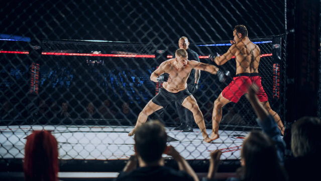 MMA Fight Shows Two Fighters Exchanging Fast Punches Inside the Cage. the Fighters Circle, Feint, and Look for Clean Contact While a Referee Stays Near