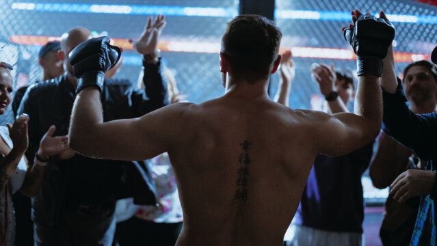 MMA Fighters Enter the Cage for a Fight as a Fighter Lifts His Gloves to the Crowd. a Tense, Championship Title Show in Martial Arts Action