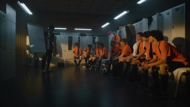 Professional Football Coach Leads Tactical Session in Locker Room, Using Flipchart to Demonstrate Game Plan to Teenage Players. Importance of Theoretical Preparation and Leadership in Youth Sports.