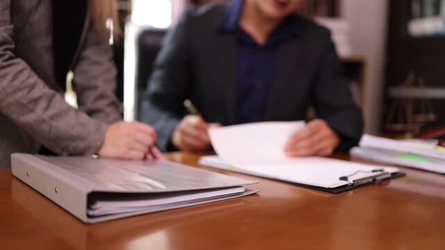 A lawyer providing legal counsel to a client, with detailed documents laid out on the desk and a judge's gavel nearby, symbolizing professionalism, legal consultation, and the judicial process.