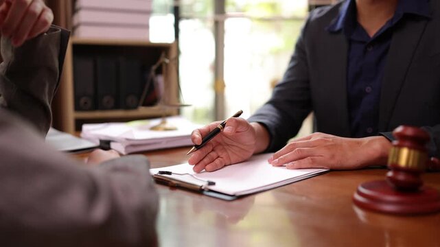 A lawyer providing legal counsel to a client, with detailed documents laid out on the desk and a judge's gavel nearby, symbolizing professionalism, legal consultation, and the judicial process.