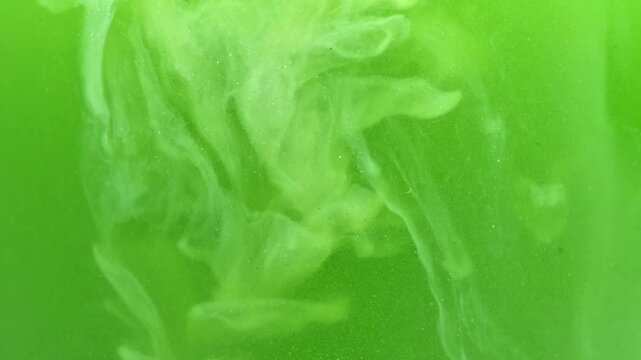 Slow motion macro close-up of pouring cream into matcha latte drink