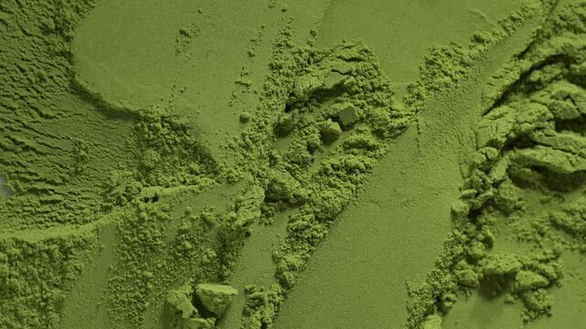 Close-up of bamboo chashaku scoop taking matcha green tea powder with moringa spirulina chlorella superfoods


