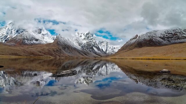 4K time lapse footage of beautiful snow covered mountains with moving rolling clouds and peaceful lake, Ama Drime Snow Mountain Dingjie Zongcuo Lake in Dingjie, Shigatse, Tibet, China. Travel concept.