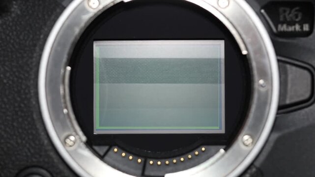 Extreme close-up of a mirrorless camera sensor with the mechanical shutter curtain triggering as it rapidly moves up and down, revealing the precision and speed of modern camera technology.
