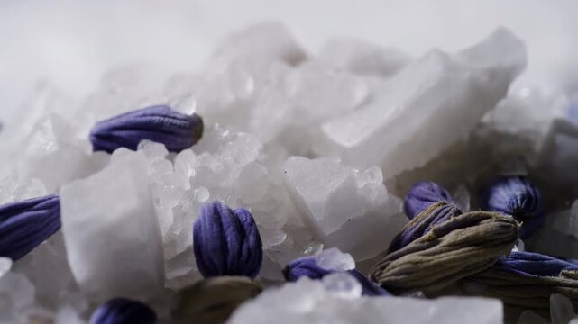 Close view of dried lavender buds resting among coarse white salt crystals in soft diffuse light with subtle settling motion and rich natural texture, with lavender, salt, crystal, buds detail