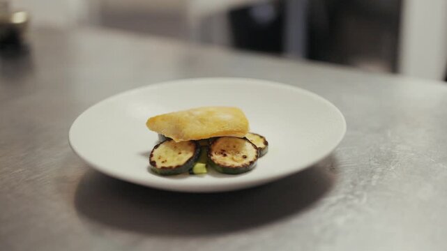 Gourmet zucchini appetizer with yellow sauce on a white plate