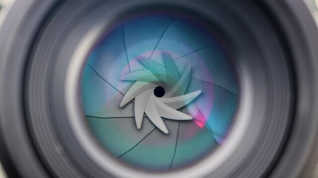 Close-up macro shot of a camera lens aperture smoothly opening from a narrow to a wide setting, revealing the precision of optical mechanics