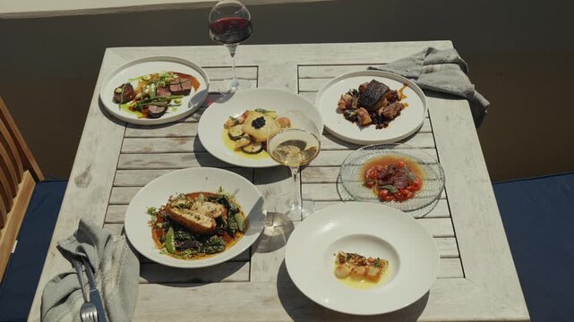Tasting menu with wine on a weathered wooden table overlooking ocean