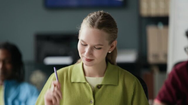 Tilt up of young adult Caucasian woman drumming on desk items with pen and pencil during office break. Perfect for corporate wellness, stress management, or workplace culture marketing campaigns