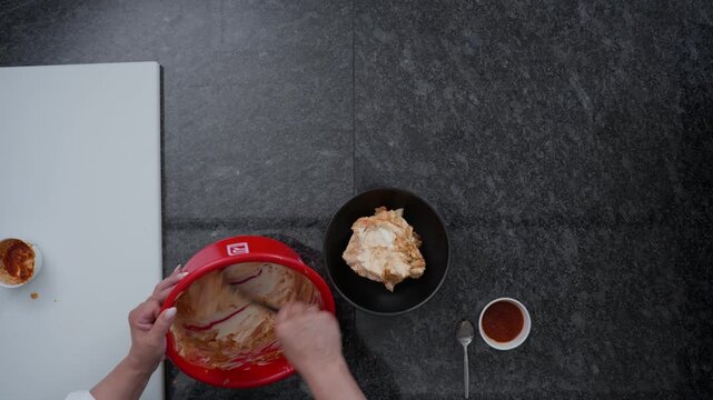 Chef plating a creamy dish in a commercial kitchen. Food preparation footage showing catering, cooking and hospitality concepts in a professional kitchen setting, top-down close-up