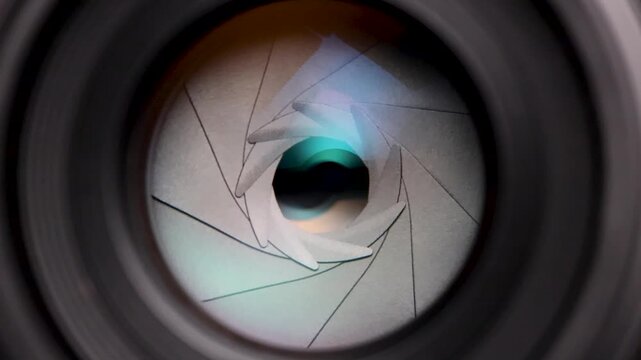 Close-up macro shot of a camera lens aperture smoothly opening from a narrow to a wide setting, revealing the precision of optical mechanics