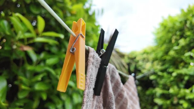 Towel Hanging From Washing Line With Clothes Pegs In Green Summer Garden