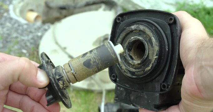 Close-up of a heavily scaled pump rotor and stator removed for inspection. Maintenance concept of limescale buildup, pump repair, cleaning, and mechanical servicing.