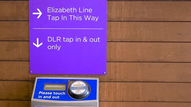 Purple sign and contactless reader direct passengers how to tap in and out for the Elizabeth Line and DLR.