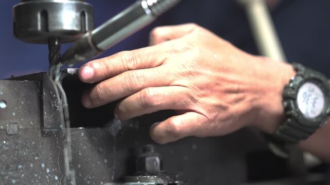 Experienced Metalworker Using Hand File on Steel Plate for Precision Finishing in Local Machine Shop