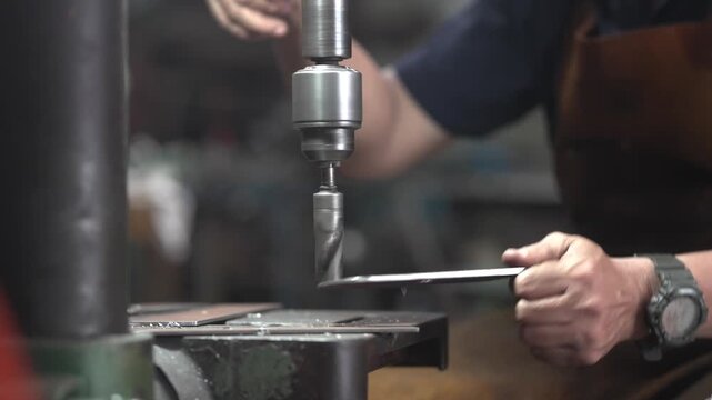 Skilled Machinist Operating Drill Press Machine in Small Community Metalworking Workshop