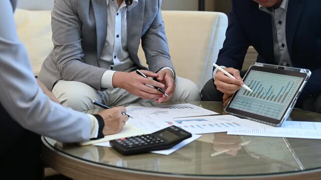 Successful business team analyzing financial growth charts on digital tablet at homeoffice to representing sustainable business success, ROI, and financial freedom.