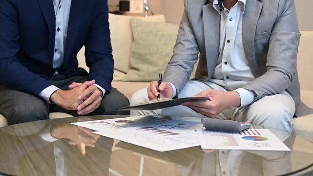 Successful business team analyzing financial growth charts on digital tablet at homeoffice to representing sustainable business success, ROI, and financial freedom.